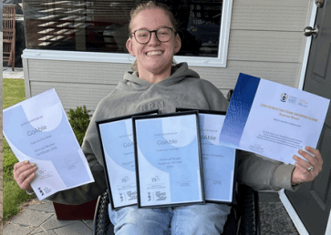 Daisy holding Go Able award certificates